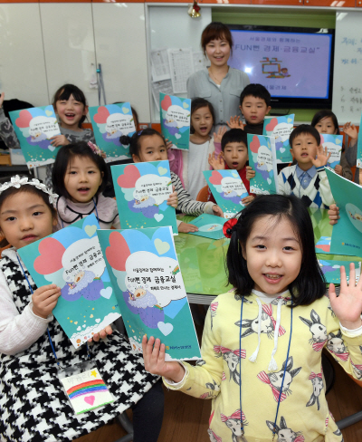 8일 ‘서울경제와 함께하는 경제·금융교실’에 참여한 서울 성동구 동호초등학교 1·2학년 학생들이 교재를 들어보이고 있다./이호재기자