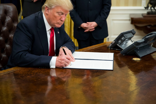 도널드 트럼프 미국 대통령이 백악관 집무실에서 행정 명령에 서명하고 있다.