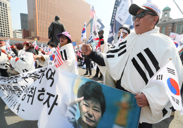 박근혜 전 대통령 탄핵 1년인 10일 오후 서울역광장에서 대한애국당 주최로 열린 태극기집회에서 참가자들이 박 전 대통령의 석방을 촉구하며 태극기를 흔들고 있다. /연합뉴스