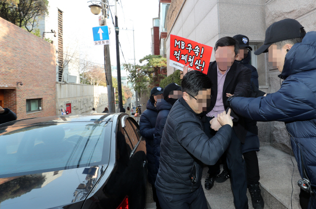 이명박 전 대통령의 검찰 소환조사를 사흘 앞둔 11일 서울 강남구 논현동 이 전 대통령 자택 앞에서 한 시민이 “이 전 대통령 구속”을 외치다 경찰들에게 제지당하고 있다. /연합뉴스