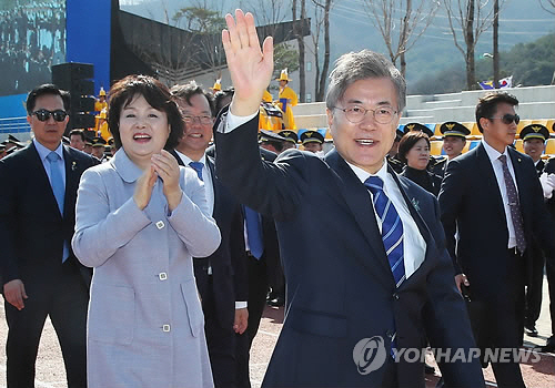 문재인 대통령과 부인 김정숙 여사가 13일 오후 충남 아산 경찰대학에서 열린 2018년 경찰대학생·간부후보생 합동 임용식을 마친 뒤 퇴장하며 신임 임용 간부들의 환송을 받고 손을 흔들고 있다./연합뉴스