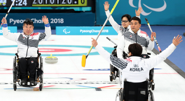 정승원(왼쪽) 등 한국 휠체어컬링 대표팀 선수들이 15일 중국전에서 승리한 뒤 기뻐하고 있다. /연합뉴스
