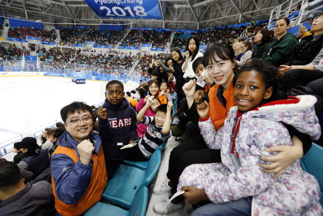 한화 직원들과 서울 구로구 지구촌지역아동센터에 소속된 다문화가정 아동들이 15일 강원 강릉하키센터에서 열린 한국과 캐나다의 아이스하키 경기를 관전하며 파이팅을 외치고 있다. 한화그룹은 평창동계패럴림픽에 다문화가정 어린이들을 초청해 경기를 관람하고 함께 국가대표팀을 응원했다. /사진제공=한화그룹