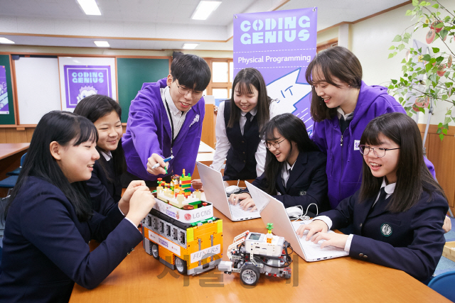 지난 14일 서울 서대문구 동명여자중학교에서 올해 처음으로 진행된 ‘코딩 지니어스’에 참여한 중학생들이 대학생 자원봉사자들과 코딩 실습을 하고 있다./사진제공=LG CNS