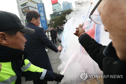 지난 1월 22일 오전 서울역 광장에서 조원진 대한애국당 대표와 당원들이 ‘기자회견 평양올림픽? 평창올림픽 반대 기자회견 한반도기, 인공기 화형식 거행!’을 진행하자 경찰이 소화기로 진압하고 있다./연합뉴스