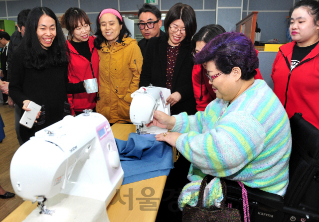 미싱 전문브랜드 ‘소잉팩토리 부라더미싱’이 장애인 자립활동을 위한 재봉틀을 기증, 지난 15일 ‘사)경기장애인자립생활센터협의회 수원시지부, 수원새벽빛장애인자립센터’ 대강당에서 기증식이 진행됐다. 센터 회원이 휠체어를 이용하는 장애인도 사용할 수 있는 부라더미싱의 재봉틀 ‘캠퍼스300’ 시연해 보고 있다./사진제공=부라더미싱