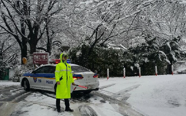 21일 오전 부산지역에 눈이 내리면서 산간지역 도로 곳곳이 통제됐다. 경찰이 금정산 산간도로의 차량 통행을 통제하고 있다./사진제공=부산경찰청