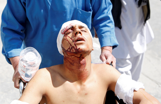 아프가니스탄 카불에서 21일(현지시간) 발생한 테러로 부상을 입은 한 시민이 휠체어를 탄 채 이동하고 있다. 이슬람 극단주의 무장단체 이슬람국가(IS)는 배후를 자처했다.     /카불=로이터연합뉴스