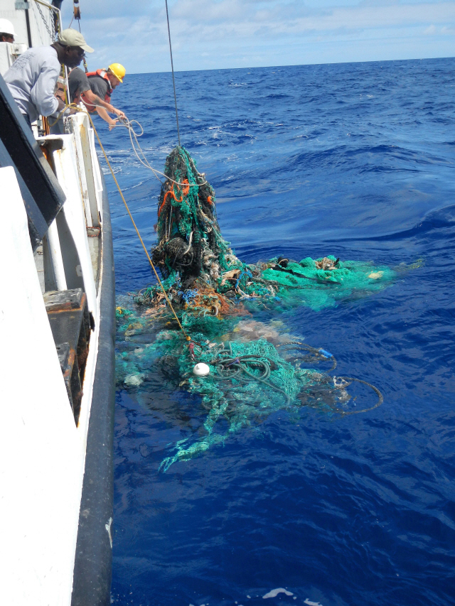 국제 환경연구기관 ‘오션 클린업 파운데이션’이 22일(현지시간) 공개한 사진에서 연구진이 태평양의 해양 쓰레기를 끌어올리고 있다. /태평양=AFP연합뉴스