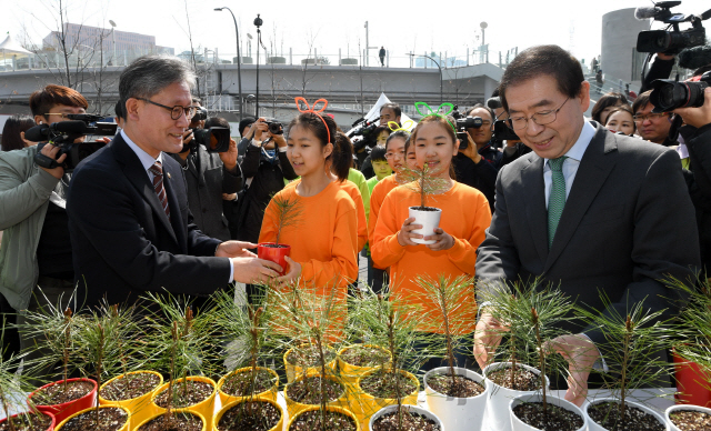 김재현(사진 왼쪽 첫번째) 산림청장과 박원순(〃네번째) 서울시장이 어린이들에게 소나무 묘목을 나눠주고 있다. 사진제공=산림청