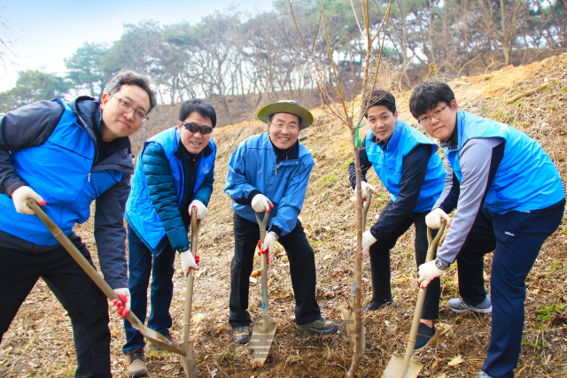 윤동한(가운데) 한국콜마 회장과 임직원들이 24일 경기도 여주 산림개간지에서 진행된 나무심기 행사에서 식목을 위한 땅 다지기를 하고 있다. /사진제공=한국콜마