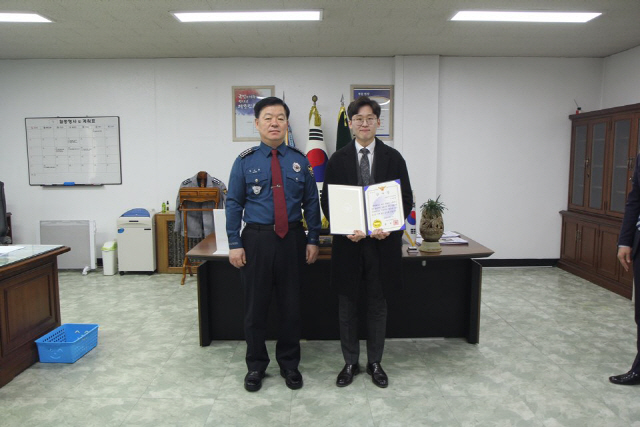 NH농협은행 북인천 지점에서 일하고 있는 이태영(오른쪽) 수습 계장이 경찰로부터 금융사기 예방 공로를 인정받아 감사장을 받은 후 환하게 웃고 있다. /사진제공=NH농협은행