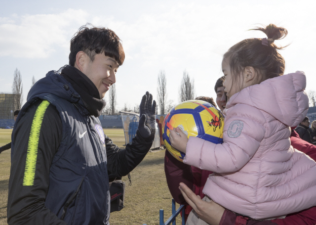 축구 대표팀 손흥민이 26일 폴란드 호주프에서의 회복훈련 중 훈련장을 찾은 꼬마 팬에게 인사하고 있다. /연합뉴스