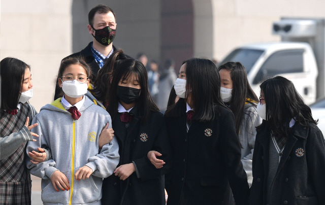 미세먼지 비상저감조치가 내려진 지난 26일 서울 광화문 거리에서 학생들이 마스크를 쓴 채 발길을 재촉하고 있다.     /송은석기자