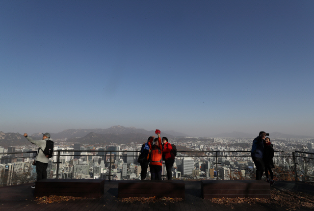 지난해 11월 남산에서 바라본 서울 하늘에 황사 영향으로 보이는 옅은 누런색 띠가 보이는 가운데 가을 나들이객들이 도심을 배경으로 한 셀카를 찍고 있다. /연합뉴스