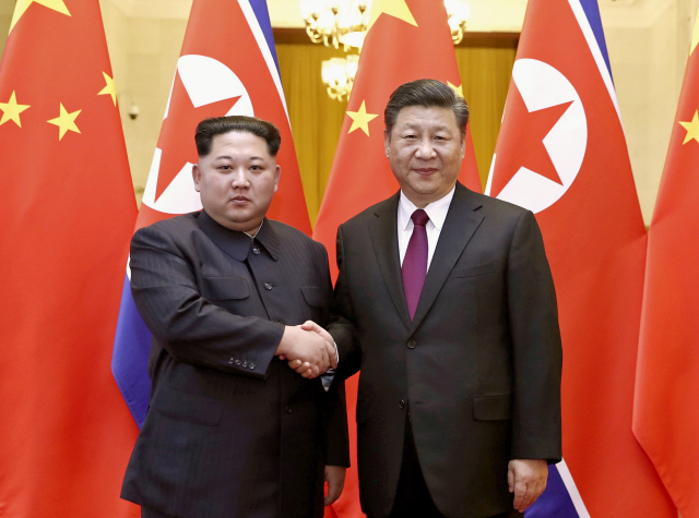 시진핑(오른쪽) 중국 국가주석이 28일(현지시간) 베이징에서 김정은 북한 노동당 위원장과 만나 악수를 하고 있다. /베이징=신화연합뉴스