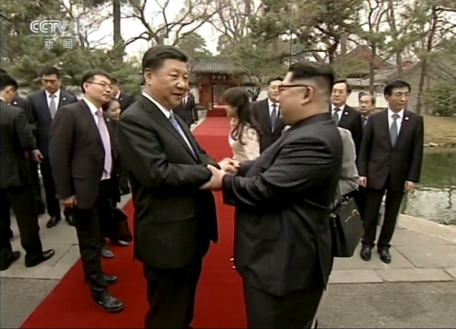 시진핑(왼쪽) 중국 국가주석과 김정은 북한 노동당 위원장이 베이징 국빈관 댜오위타이에서 악수를 누나고 있다. 사진은 28일 중국 중앙(CC)TV 화면을 캡쳐한 것이다. /연합뉴스