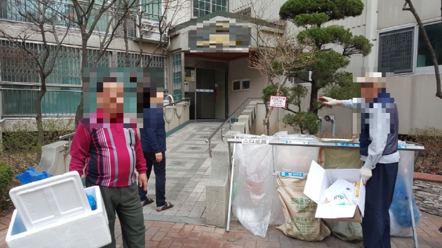 서울의 한 아파트에서 2일 재활용품 수거 업체 직원(오른쪽)이 주민들에게 분리배출 방법을 설명하고 있다.  /오지현기자