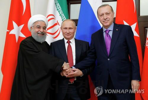 블라디미르 푸틴(가운데) 러시아 대통령이 지난해 11월 22일 러시아 소치에서 하산 로하니 이란 대통령 그리고 레제프 타이이프 에르도안 터키 대통령과 공동회담을 갖고 기념 촬영을 하고 있다. /타스연합뉴스