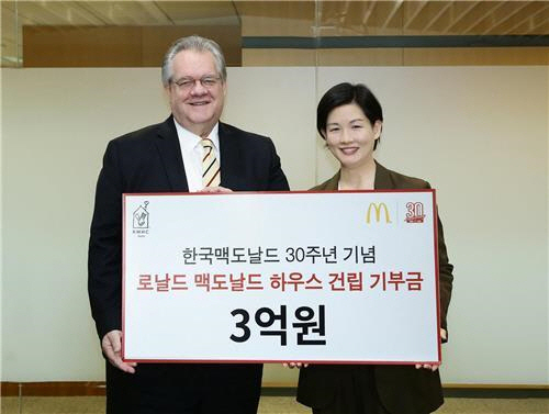 조주연(오른쪽) 한국맥도날드 사장이 최근 제프리 존스 한국로날드맥도날드하우스(RHMC 코리아) 회장에게 기부금을 전달하며 기념촬영을 하고 있다.  한국 진출 30주년 기념행사에서 판매된 빅맥과 해피밀 수익금 3억원을 중증 질병 어린이 치료에 도움줄 로날드맥도날드하우스 건립에 사용토록 기부한 것이다. /사진제공=맥도날드