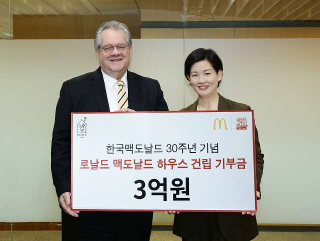 조주연(오른쪽) 한국맥도날드 사장이 4일 서울시 종로구 맥도날드 본사에서 제프리 존스(Jeffrey Jones) RMHC Korea회장에게 국내 1호 한국로날드맥도날드하우스 건립을 위한 기부금 3억원을 전달하고 있다. 이 기부금은 한국 진출 30주년을 맞이해 지난달 29일 진행한 ‘맥도날드 30주년 생일 이벤트’에서 판매된 빅맥과 해피밀 수익금으로 이뤄졌다. 한국로날드맥도날드하우스는 중증 질병으로 오랜 기간 입원해야하는 어린이 환자와 가족들이 병원 근처에 머물며 편히 치료를 받을 수 있는 공간이다. /사진제공=한국맥도날드