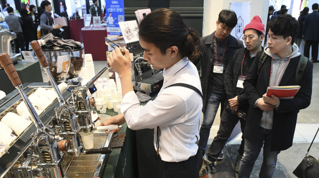 5일 서울 강남구 코엑스에서 열린 ‘2018 서울커피엑스포’에서 한 바리스타가 관람객들에게 시음용 커피를 나눠주고 있다./송은석기자