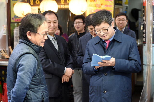 염태영(오른쪽) 수원시장이 구매탄시장 상인으로부터 건의사항을 들으며 메모하고 있다. /사진제공=수원시청