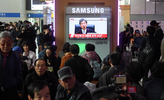 박근혜 전 대통령의 국정농단 사건 1심 선고 공판이 진행중인 6일 오후 서울 용산구 서울역 대합실에서 시민들이 중계를 시청하고 있다./권욱기자