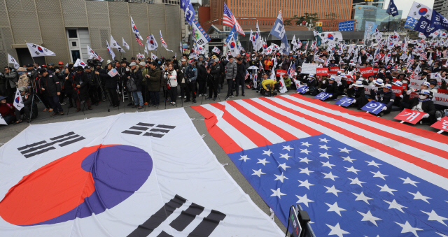 지난 7일 서울역광장에서 대한애국당과 보수단체 회원들이 태극기와 성조기를 펼쳐놓고 박근혜 전 대통령 석방을 촉구하는 집회를 하고 있다.  /연합뉴스