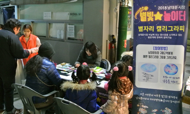 7일 ‘남대문시장 야간대축제 별빛놀이터’에서 관광객들이 캘리그라피를 그리고 있다. /김정욱기자