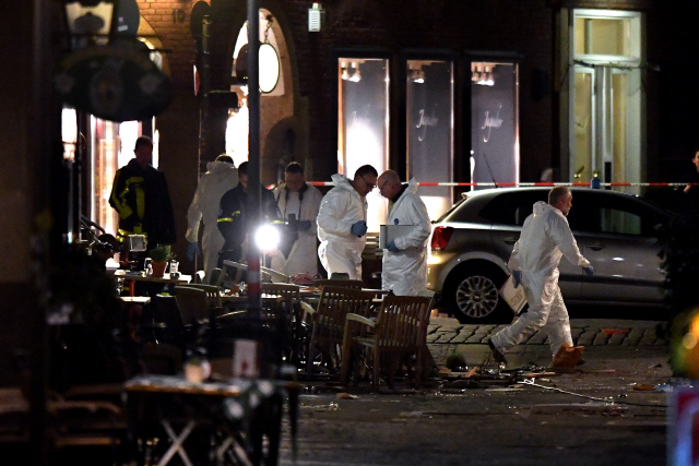 8일(현지시간) 독일 경찰들이 트럭 돌진사고가 발생한 뮌스터시의 한 레스토랑 야외 테이블 주변을 감식하고 있다. /뮌스터=EPA연합뉴스