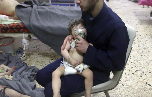 시리아 동구타 두마지역에서 정부군의 화학무기 공격이 감행됐다는 보도가 나온 후 8일(현지시간) 두마에서 한 자원봉사자가 어린이의 입에 산소 마스크를 씌우고 있다./AP연합뉴스