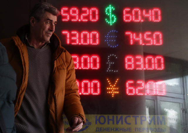 미국의 대러 추가 제재 조치에 루블화 가치가 크게 떨어진 9일(현지시간) 러시아 모스크바 시내에서 한 시민이 시세판 앞을 지나가고 있다. /모스크바=타스연합뉴스