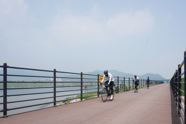 SK케미칼의 에코젠이 적용된 목재 플라스틱 복합재 자전거 도로 위를 자전거가  달리고 있다. /사진제공=SK케미칼