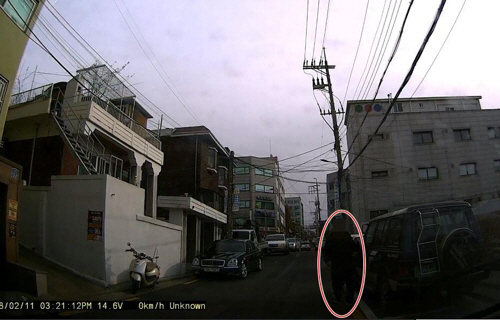 지난 2월 11일 서울 금천구의 한 골목에서 민모(42)씨가 서행하는 차량을 대상으로 보험사기를 벌이기 위해 차량 쪽으로 접근하고 있다./사진=금천경찰서