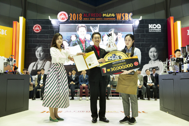 박수혜(오른쪽) 바리스타가 이영성(가운데) 서울커피엑스포 위원장으로부터 우승 트로피와 상금을 받고 있다. /사진제공=KCA