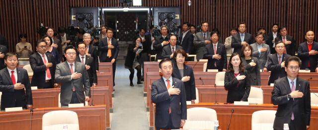 김성태 자유한국당 원내대표(앞줄 가운데)와 함진규 정책위의장 등 참석 의원들이  9일 국회에서 열린 의원총회에서 국기에 대한 경례를 하고 있다. /연합뉴스