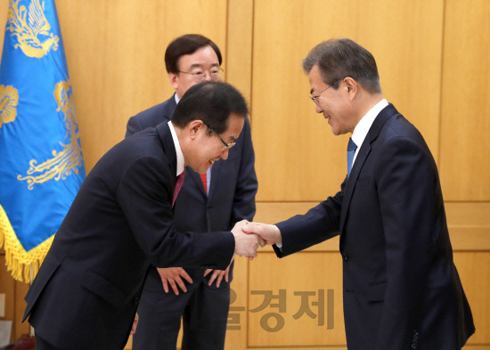 문재인(오른쪽) 대통령이 13일 청와대에서 홍준표 자유한국당 대표를 만나 악수하고 있다. /연합뉴스