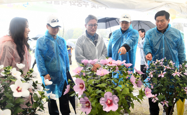 14일 서울경제신문과 산림청·수원시 공동주최로 수원 광교호수공원 '재미난밭'에서 '달팽이 마라톤' 대회가 열렸다. 김재현(가운데) 산림청장과 이종환(오른쪽 두 번째) 서울경제신문 대표이사 부회장, 권영은(왼쪽) 우리꽃 무궁화박물관장 등이 한지로 만든 무궁화 나무 작품을 살펴보고 있다. 이날 무궁화 전시는 산림청이 추진하는 도시녹화운동을 홍보하기 위해 마련됐다./광교=권욱기자ukkwon@sedaily.com