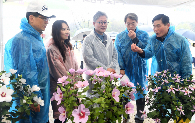 14일 서울경제신문과 산림청·수원시 공동주최로 수원 광교호수공원 '재미난밭'에서 '달팽이 마라톤' 대회가 열렸다. 김재현(가운데) 산림청장과 이종환(오른쪽 두 번째) 서울경제신문 대표이사 부회장, 권영은(왼쪽 두 번째) 우리꽃 무궁화박물관장 등이 한지로 만든 무궁화 나무 작품을 살펴보고 있다. 이날 무궁화 전시는 산림청이 추진하는 도시녹화운동을 홍보하기 위해 마련됐다./광교=권욱기자ukkwon@sedaily.com