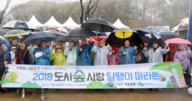 14일 서울경제신문·산림청·수원시 공동주최로 수원 광교호수공원에서 열린 ‘달팽이 마라톤’에서 이종환(앞줄 왼쪽 일곱번째) 서울경제신문 대표이사 부회장과 김재현(〃 여덟번째) 산림청장 등 행사 관계자와 참가자들이 출발에 앞서 힘차게 파이팅을 외치고 있다. /수원=권욱기자