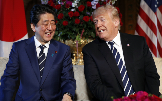 도널드 트럼프(오른쪽) 미국 대통령과 아베 신조 일본 총리가 17일(현지시간) 미일정상회담 장소인 플로리다주 팜비치 마러라고 리조트에서 대화를 나누며 환히 웃고 있다.       /팜비치=AP연합뉴스