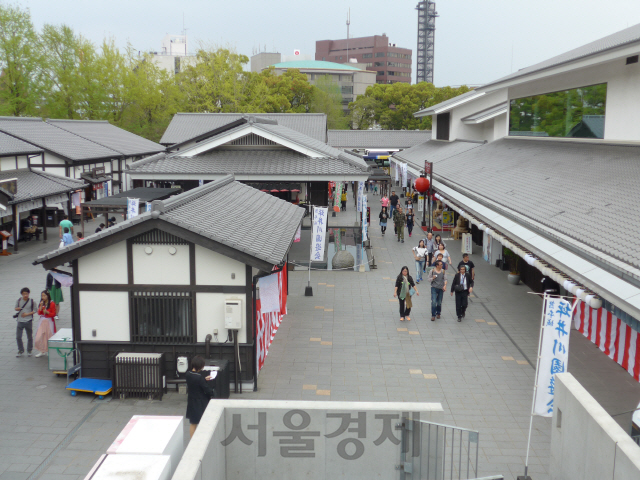 에도 시대의 마을을 재현한 사쿠라노바바 조사이엔을 찾은 방문객들이 상점가를 거닐고 있다.