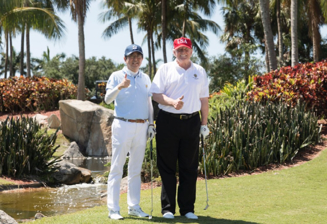 도널드 트럼프(오른쪽) 미국 대통령과 아베 신조 일본 총리가 18일(현지시간) 미국 플로리다주 팜비치의 트럼프 인터내셔널 골프 클럽에서 골프채를 들고 환히 웃고 있다. 일본 언론들은 이날 아베 총리가 시종일관 피곤한 표정이었다고 지적했다.                        /팜비치=트위터 캡처