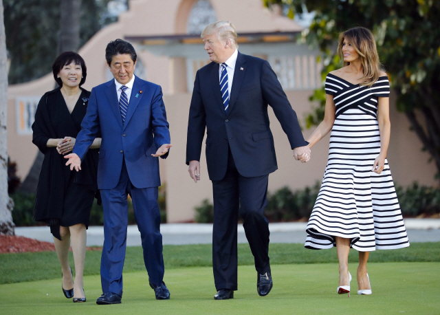 도널드 트럼프(왼쪽 세번째) 미국 대통령과 아내 멜라니아(오른쪽) 여사, 아베 신조(왼쪽 두번째) 일본 총리와 아내 아키에 여사가 지난 17일 플로리다주 팜비치의 마러라고 리조트에서 만찬장으로 이동하고 있다. 아베 총리는 트럼프 대통령과의 회담 후 비슷했던 넥타이를 바꿔 매 일본에서 “지나친 배려”라는 비판이 나오고 있다.   /팜비치=AP연합뉴스