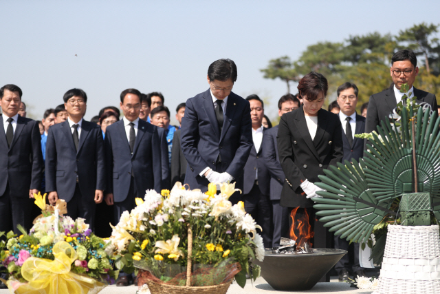 경남지사 후보인 김경수(가운데) 더불어민주당 의원이 20일 오전 부인 김정순씨와 경남 김해시 봉하마을을 찾아 노무현 전 대통령 묘역에서 묵념하고 있다. /연합뉴스