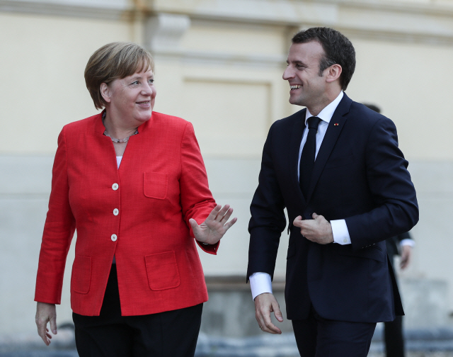 앙겔라 메르켈(왼쪽) 독일 총리가 19일(현지시간) 독일을 방문한 에마뉘엘 마크롱 프랑스 대통령과 베를린궁에서 환하게 웃으며 대화를 나누고 있다. /베를린=신화연합뉴스