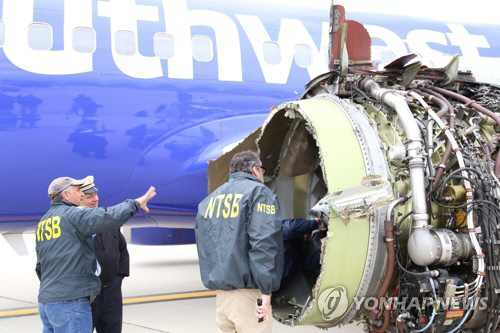 폭발한 사우스웨스트항공기 엔진을 살펴보는 미국 연방교통안전위원회(NTSB) 조사관들 모습/AP=연합뉴스