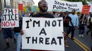 한 흑인이 자신은 ‘위험인물’이 아니라는 팻말을 들고 행진하고 있다.