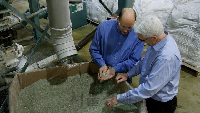 톰 그레이(오른쪽) SKC inc. 신사업 및 마케팅 총괄이 테스트를 진행한 미국 재활용업체 대표와 함께 재활용 PET칩을 살펴보고 있다. /사진제공=SKC
